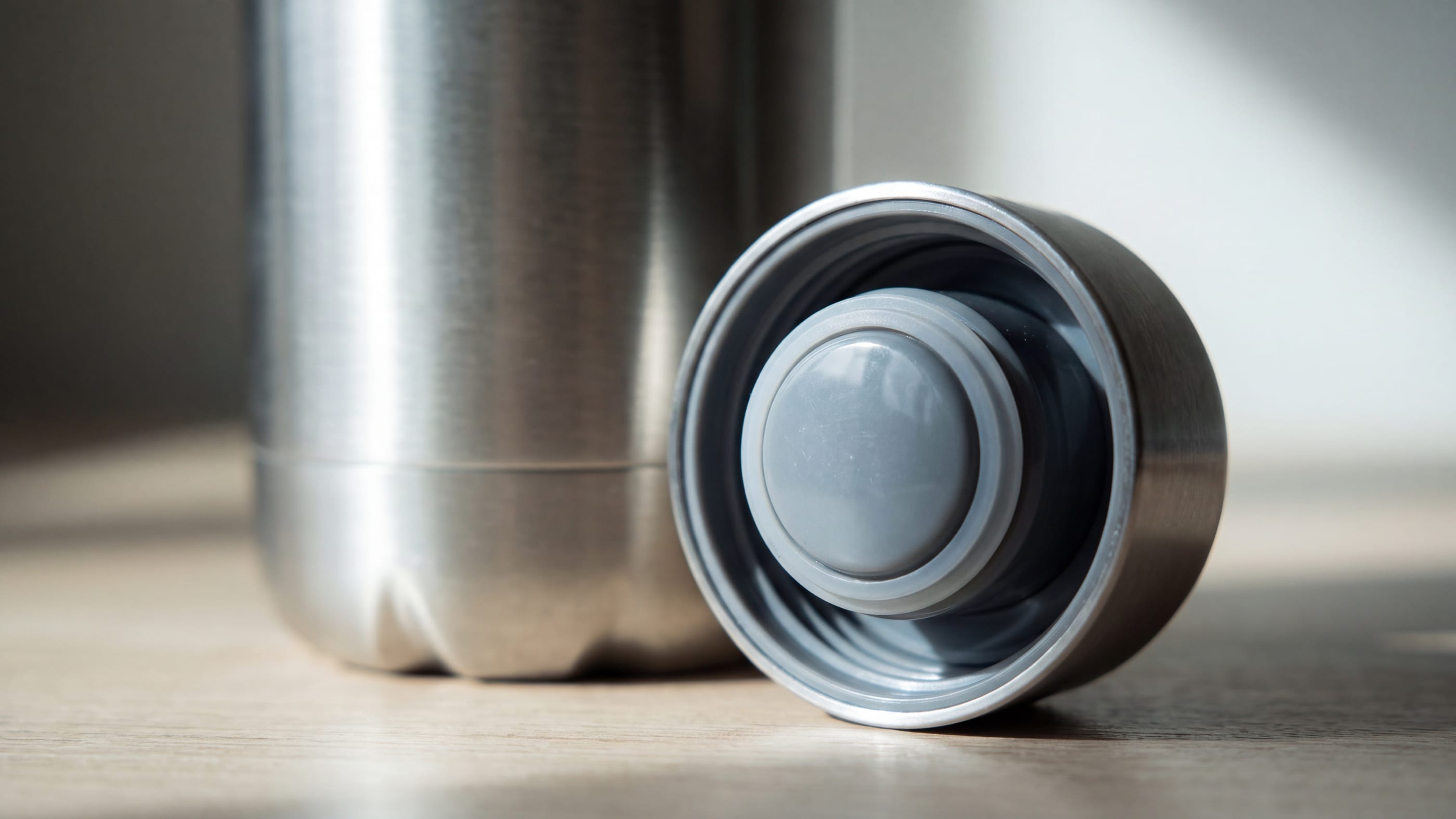 Nahaufnahme eines geöffneten Schraubdeckels einer unbedruckten Edelstahl-Trinkflasche, die Silikondichtung im Deckelinneren deutlich sichtbar.